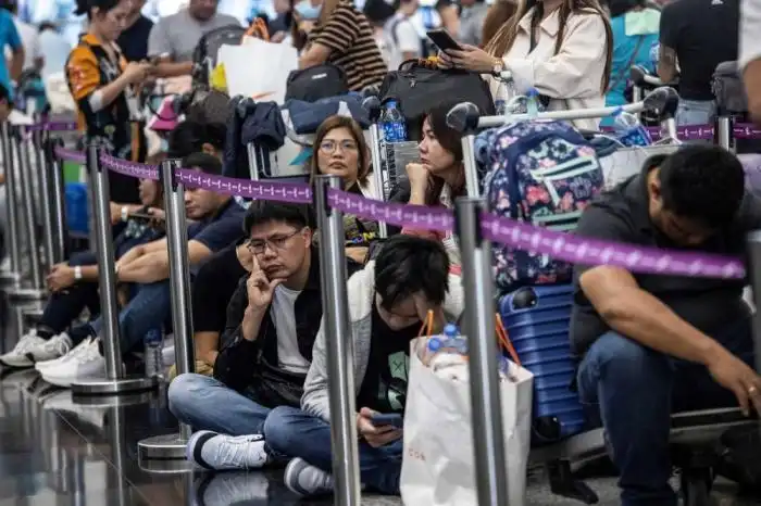 Los pasajeros esperan a ser facturados en el Aeropuerto Internacional de Hong Kong el 19 de julio de 2024, mientras algunas aerolíneas recurren al check-in manual debido a una interrupción mundial de Microsoft. (Foto de ISAAC LAWRENCE / AFP)