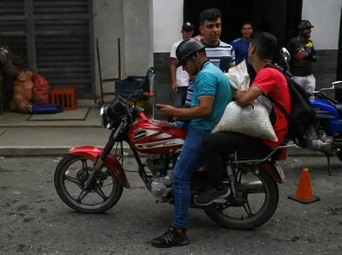 Un hombre carga un saco de café para hacer trueque por alimentos en Biscucuy, Venezuela./AFP