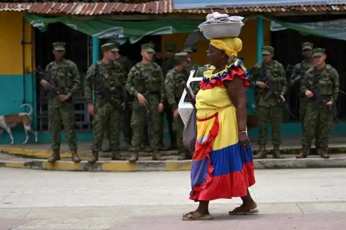 Militares ante una tradicional palenquera en la ciudad colombiana.