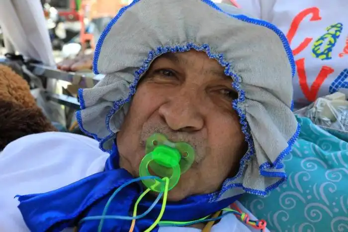 Un hombre vestido de bebé y con un chupete en la boca posa para una fotografía durante la celebración del Día Mundial de la Pereza en Itagüí, Colombia, el 18 de agosto de 2024. (Foto de JAIME SALDARRIAGA / AFP)