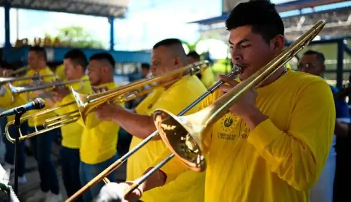 Los reclusos tocan instrumentos y cantan en una orquesta como parte del