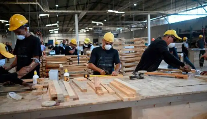 Reclusos trabajan en la fabricación de pupitres para escuelas.