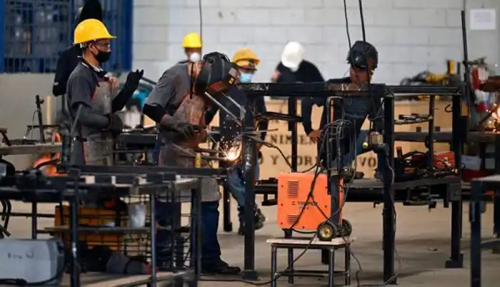 Internos trabajando en estructuras metálicas.