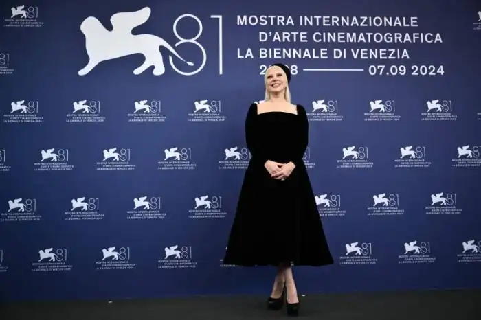 Un look mesurado y clásico pero dramático a la vez, para Gaga. Photo by Marco BERTORELLO / AFP