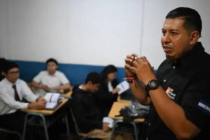 El instructor de Bitcoin Luis Contreras enseña sobre la criptomoneda y sus beneficios en una escuela secundaria pública en San Salvador el 4 de septiembre/Marvin RECINOS / AFP