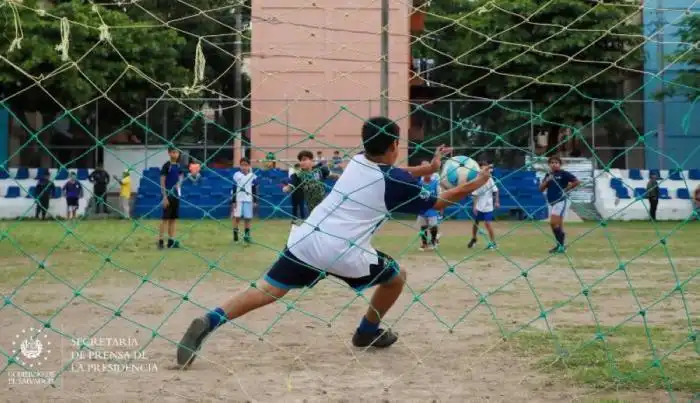 Niños jugando en la cancha de la colonia IVU, San Salvador. / Secretaría de Prensa ,image_description: