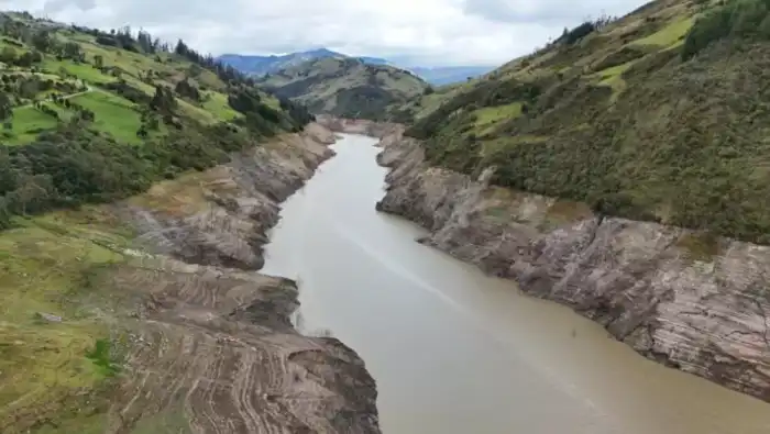 Vista aérea de la sequía en la planta hidroeléctrica de Mazar en las Palmas, Ecuador, el 18 de abril de 2024. Algunas partes de Ecuador enfrentaban cortes de energía de hasta 13 horas el jueves en medio de una crisis eléctrica provocada por una sequía que ha dejado casi reservorios hidroeléctricos clave agotado./ Foto Archivo Edwin Tapia AFP.,image_description: