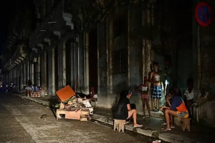 Un grupo de cubanos conversan de noche en una calle durante un apagón nacional causado por una falla en la red en La Habana el 18 de octubre de 2024./AFP