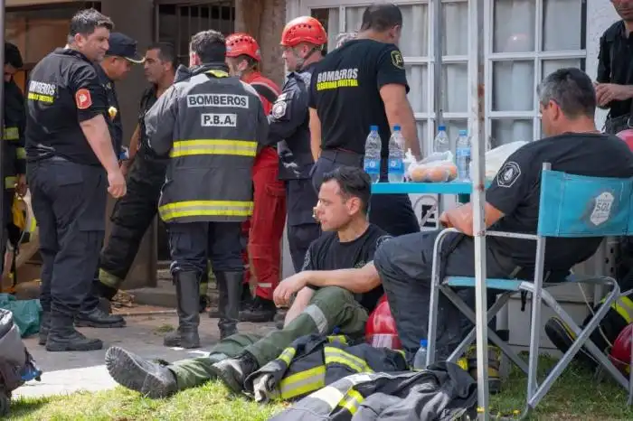 Bomberos descansan tras el derrumbe del Hotel Dubrovnik en la localidad balnearia de Villa Gesell, provincia de Buenos Aires, el 29 de octubre de 2024. Un anciano murió y una decena de personas están desaparecidas tras el derrumbe del edificio de diez pisos que albergaba un hotel el martes en la localidad balnearia argentina de Villa Gesell, informaron las autoridades locales y los medios de comunicación. (Foto STRINGER / AFP)