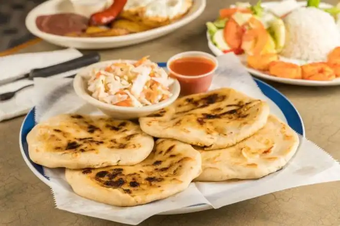 Las pupusas se acompañan tradicionalmente con su curtido y su salsa, aunque hay zonas del país donde se les agrega mayonesa y salsa negra.