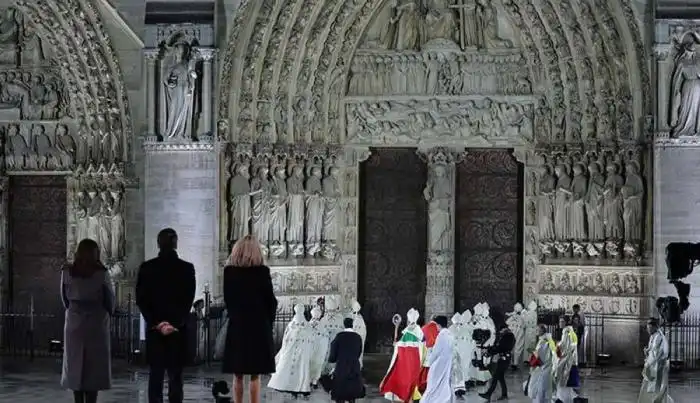 La alcaldesa de París, Anne Hidalgo; el presidente francés, Emmanuel Macron, y su esposa, Brigitte Macron, posan mientras el arzobispo de París, el obispo Ulrich, camina hacia las puertas de la catedral de Notre Dame. /AFP